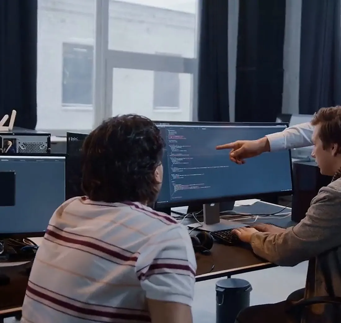 Desenvolvedores revisando código em um monitor