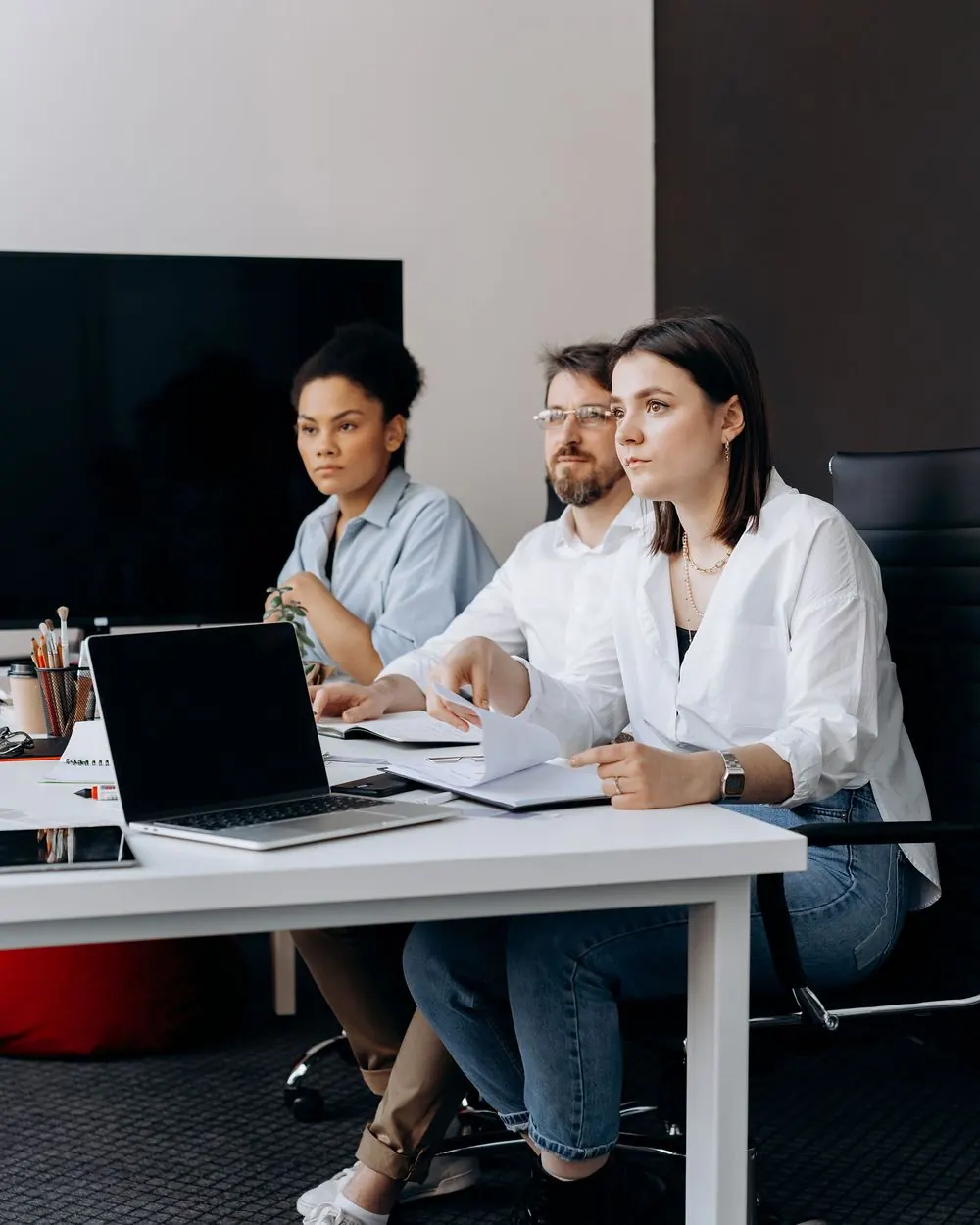 Equipe de tecnologia reunida em uma mesa com notebooks